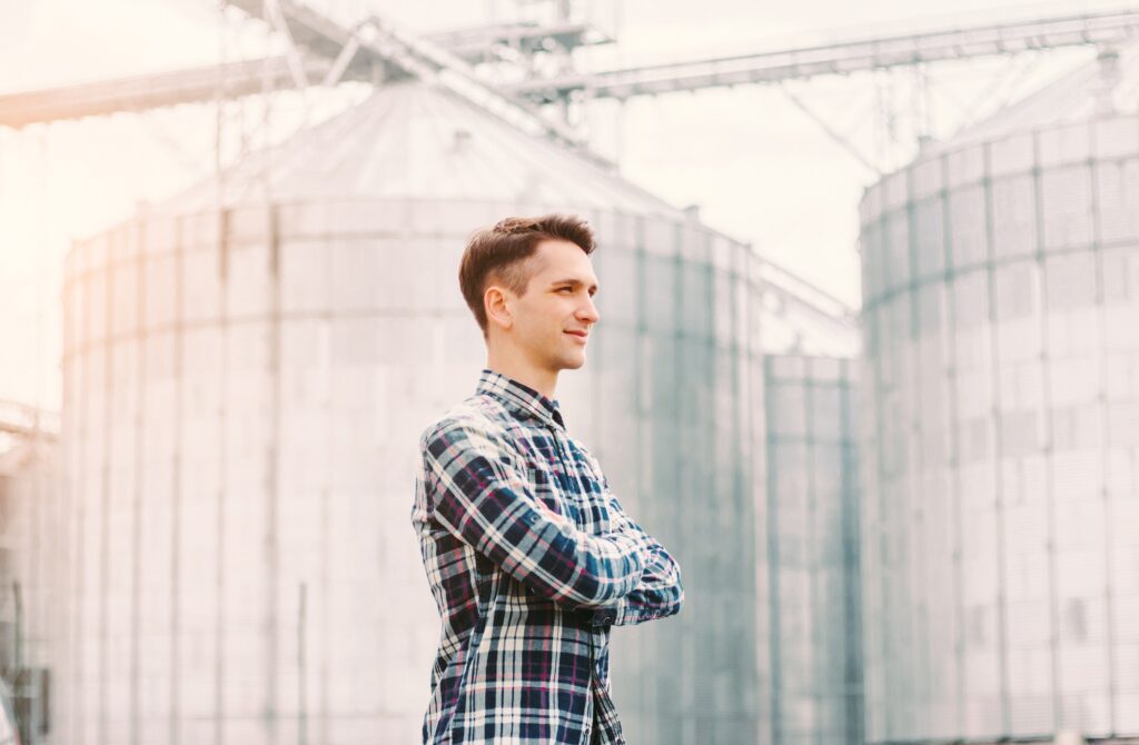 Junger Geschäftsmann vor großem Silo