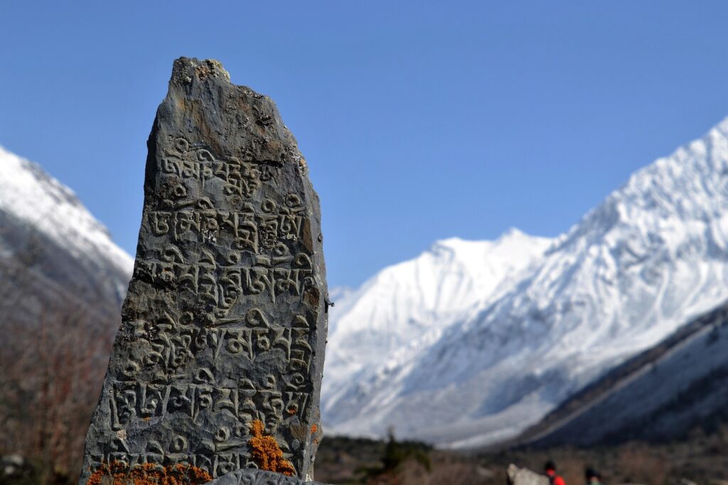 Antik beschrifteter Stein vor dem Himalaya-Massiv