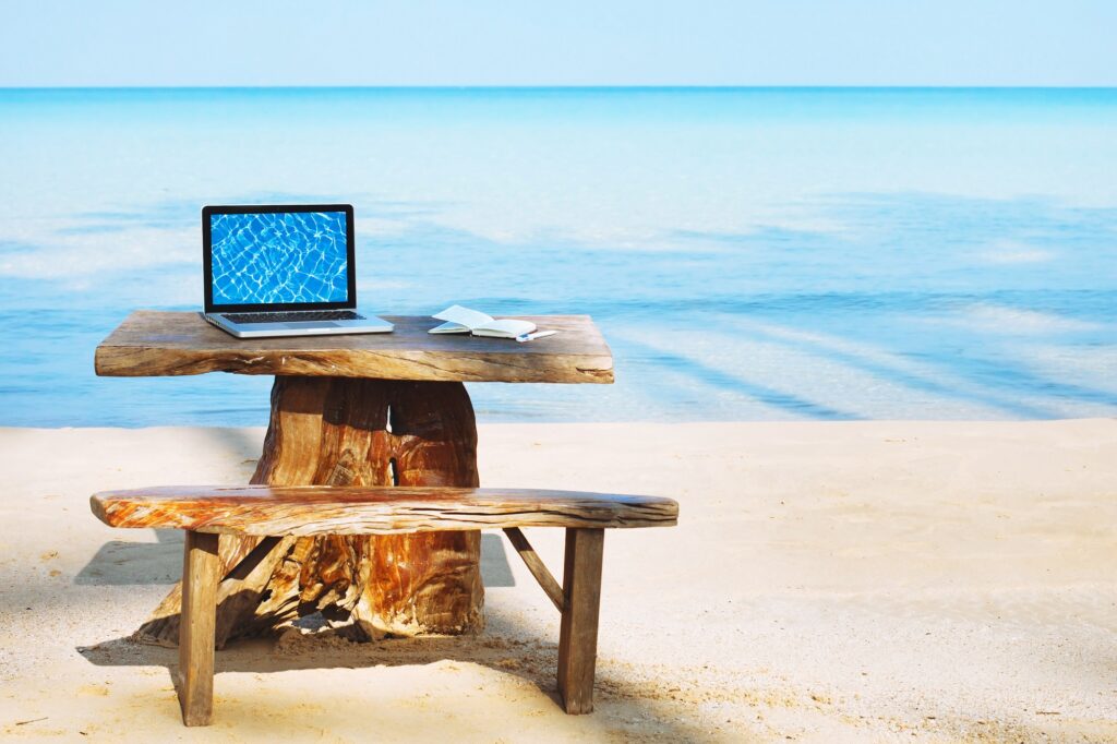 Laptop auf Holztisch am Strand