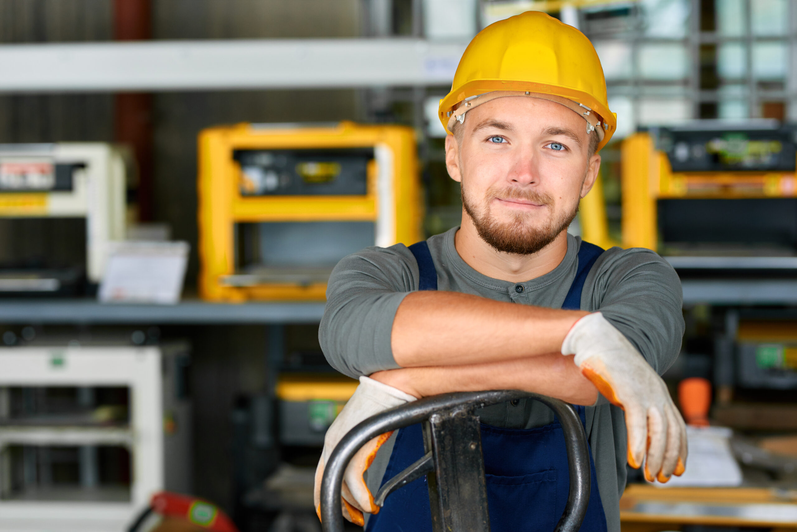Junger Handwerker in Arbeitskleidung an seinem Arbeitsplatz