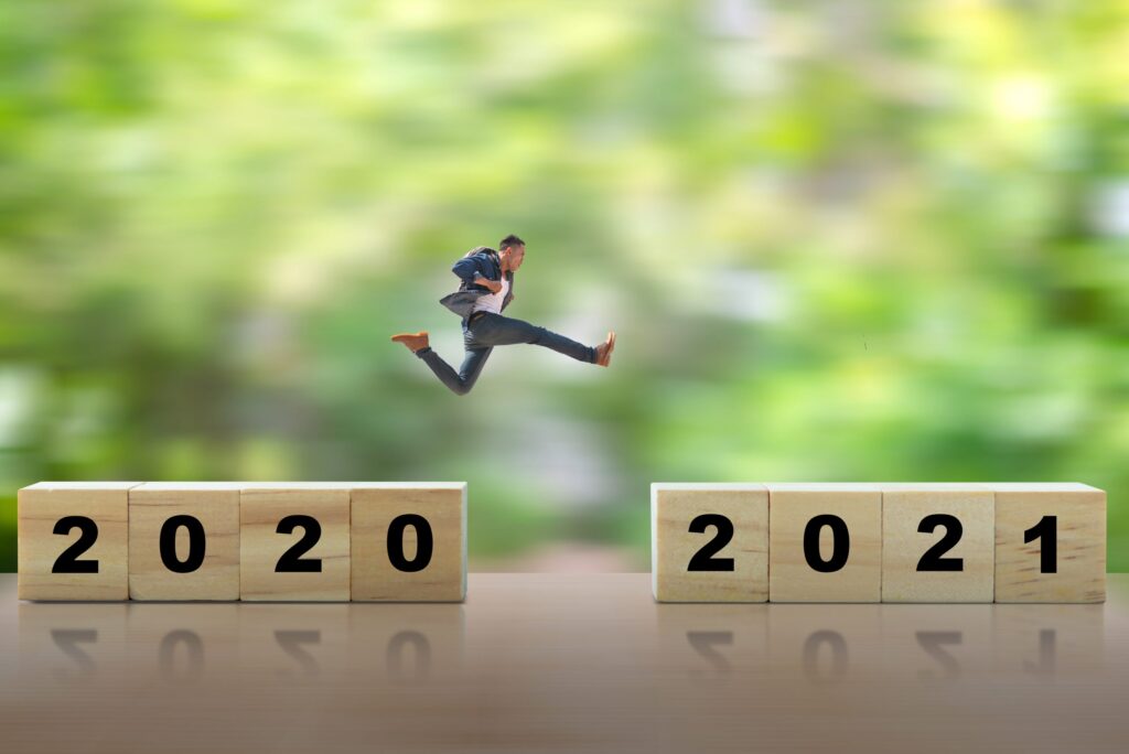 Mann springt von der Zahl 2020 zur Zahl 2020