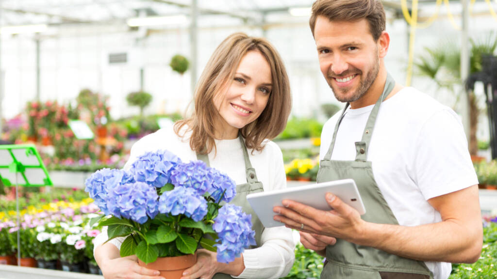 Floristin und Florist im Gartencenter oder Baumarkt bei der Arbeit