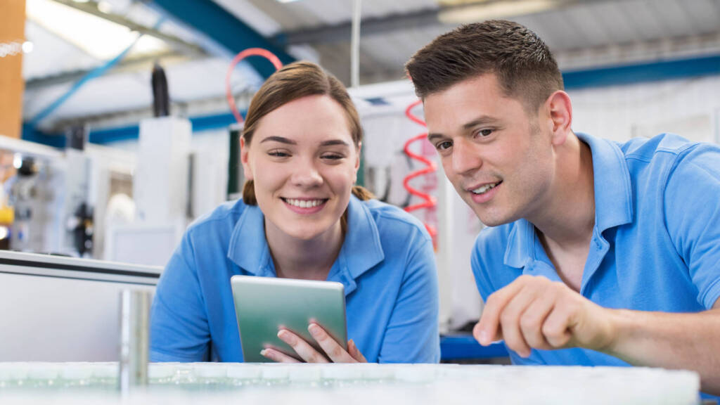 Zwei junge Auszubildende/Trainees in einem Betrieb in der Technik