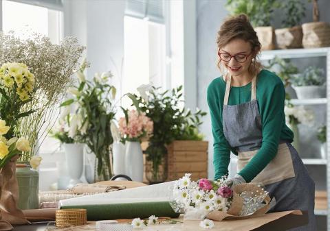 Frau bindet Blumenstrauß